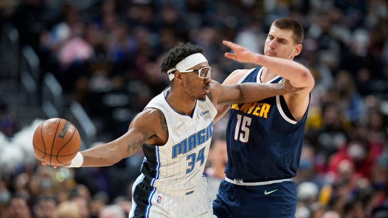Orlando Magic center Wendell Carter Jr., left, fends off Denver Nuggets center Nikola Jokic while trying to make a pass in the first half of an NBA basketball game Monday, Feb. 14, 2022, in Denver. (AP Photo/David Zalubowski)