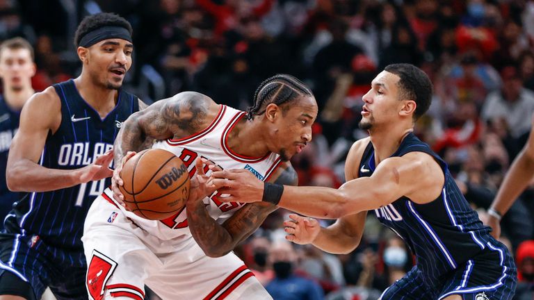 Chicago Bulls forward DeMar DeRozan, center, is defended by Orlando Magic guard Gary Harris, left, and guard Jalen Suggs, right, during the second half of an NBA basketball game, Tuesday, Feb. 1, 2022, in Chicago.
