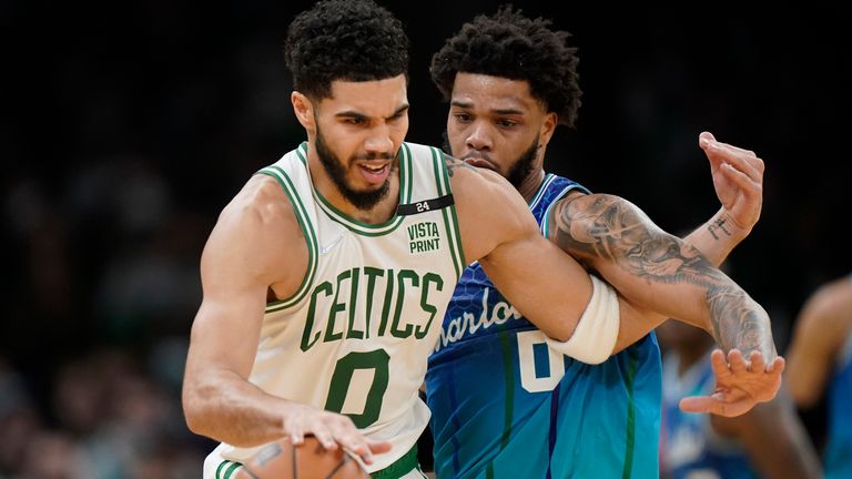 Boston Celtics forward Jayson Tatum, left, is defended by Charlotte Hornets forward Miles Bridges during the second half of an NBA basketball game, Wednesday, Feb. 2, 2022, in Boston.