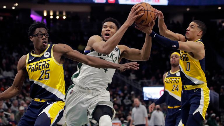 Milwaukee Bucks&#39; Giannis Antetokounmpo, middle, drives to the basket between Indiana Pacers&#39; Jalen Smith (25) and Tyrese Haliburton (0) during the second half of an NBA basketball game Tuesday, Feb. 15, 2022, in Milwaukee.