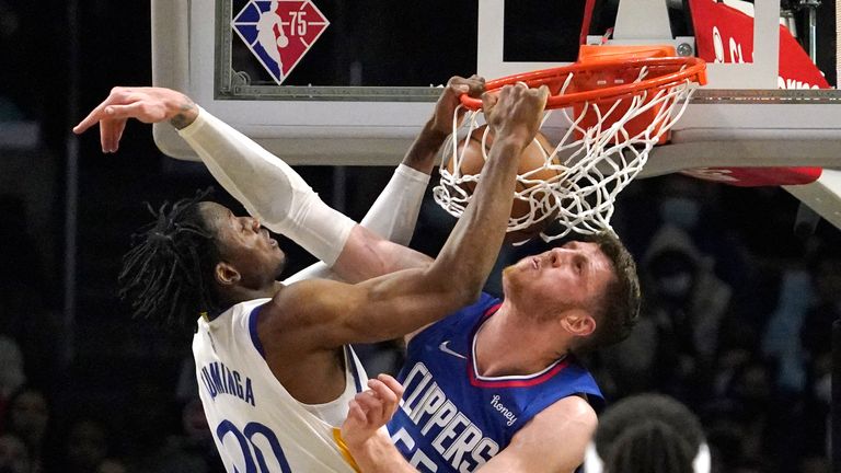 Golden State Warriors forward Jonathan Kuminga, left, dunks in the face of Los Angeles Clippers center Isaiah Hartenstein during the second half of an NBA basketball game Monday, Feb. 14, 2022, in Los Angeles. (AP Photo/Mark J. Terrill)