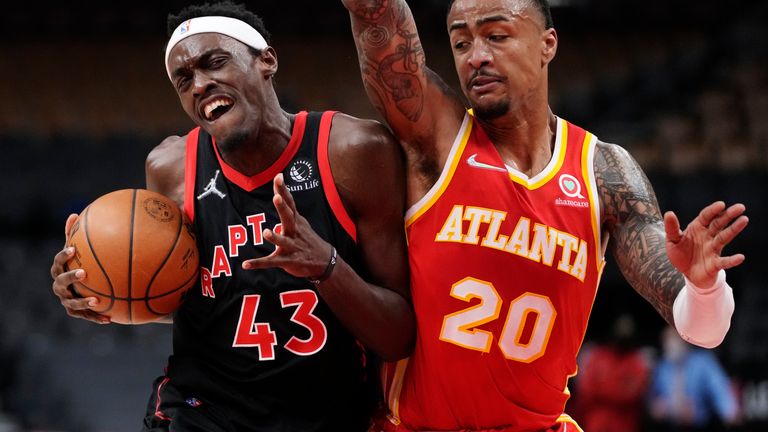Toronto Raptors forward Pascal Siakam (43) protects the ball from Atlanta Hawks forward John Collins (20) during the first half of an NBA basketball game Friday, Feb.  4, 2022, in Toronto.