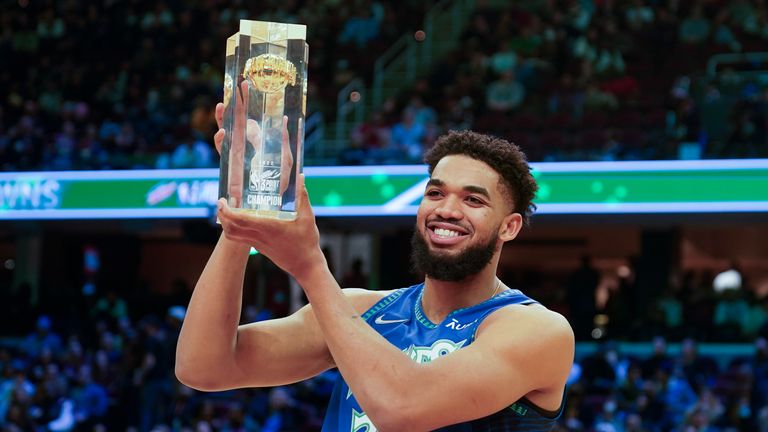 Minnesota Timberwolves&#39; Karl-Anthony Towns holds up the trophy after winning the three-point shot part of the skills challenge competition, part of NBA All-Star basketball game weekend, Saturday, Feb. 19, 2022, in Cleveland.