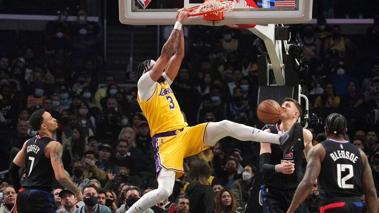 Los Angeles Lakers forward Anthony Davis, second from left, dunks as Los Angeles Clippers guard Amir Coffey, left, center Isaiah Hartenstein, second from right, and guard Eric Bledsoe defend during the first half of an NBA basketball game 