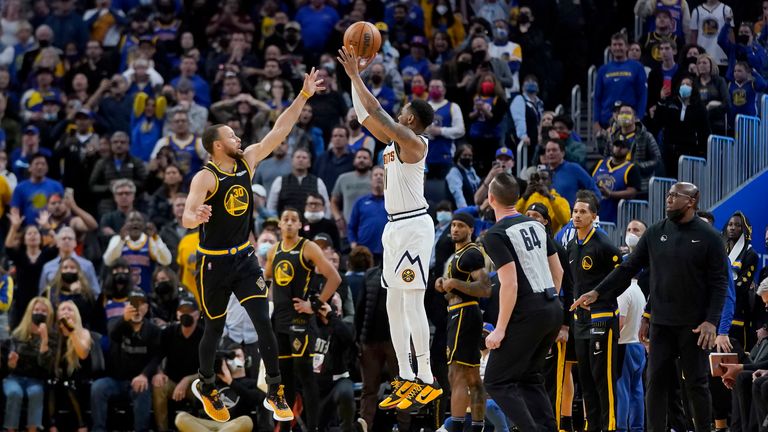 Denver Nuggets guard Monte Morris, middle, shoots a 3-point basket at the final buzzer over Golden State Warriors guard Stephen Curry during an NBA basketball game in San Francisco