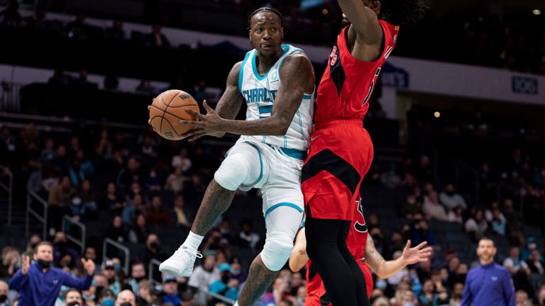 Charlotte Hornets guard Terry Rozier (3) drives to the basket while guarded by Toronto Raptors forward Precious Achiuwa (5) during the first half of an NBA basketball game in Charlotte, N.C., Monday, Feb. 7, 2022. (AP Photo/Jacob Kupferman)



