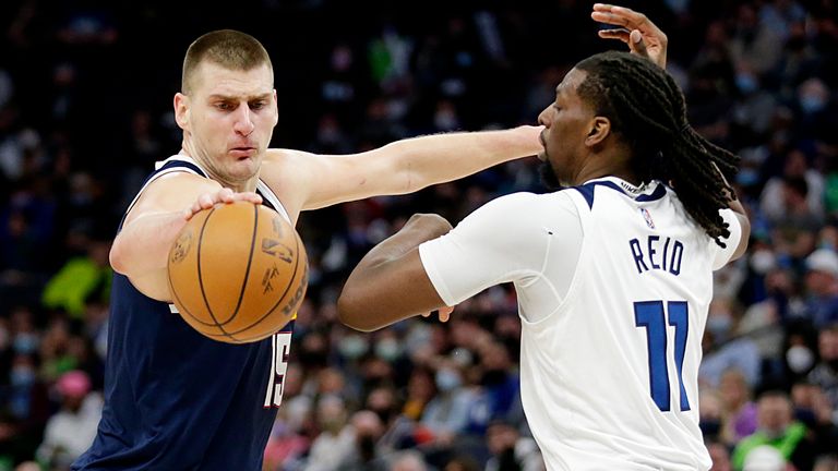 Denver Nuggets center Nikola Jokic (15) controls the ball in front of Minnesota Timberwolves center Naz Reid (11) during the second half of an NBA basketball game Tuesday, Feb. 1, 2022, in Minneapolis.