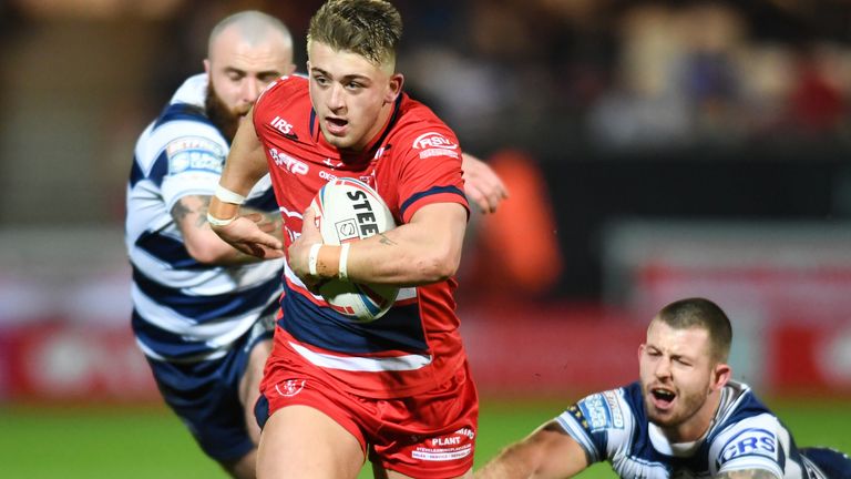 Mikey Lewis runs for the tryline as Jake Bibby and Cade Cust of Wigan Warriors reach to tackle