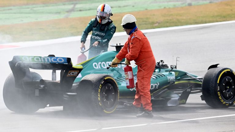 Marshals assist Sebastian Vettel after a technical failure on his Aston Martin