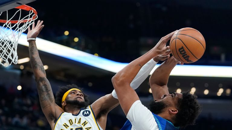Minnesota Timberwolves&#39; Karl-Anthony Towns (32) has his shot blocked by Indiana Pacers&#39; Oshae Brissett (12) 