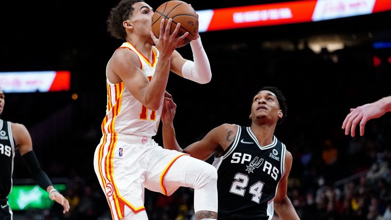Atlanta Hawks guard Trae Young drives to the basket as San Antonio Spurs guard Devin Vassell defends during the first half of an NBA basketball game Friday, Feb. 11, 2022, in Atlanta.
