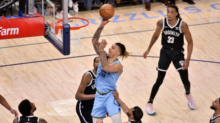 Memphis Grizzlies forward Brandon Clarke (15) shoots against Brooklyn Nets forwards Bruce Brown (1) and Kevin Durant, center rear, during the second half of an NBA basketball game Wednesday, March 23, 2022, in Memphis, Tenn.