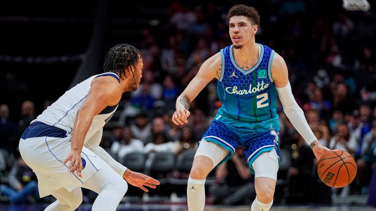 Charlotte Hornets guard LaMelo Ball brings the ball up court against Dallas Mavericks guard Jalen Brunson during the first half of an NBA basketball game Saturday, March 19, 2022, in Charlotte, N.C.