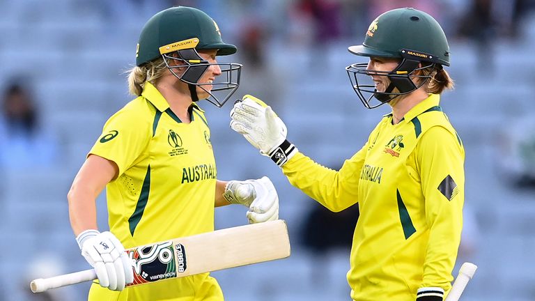 Alyssa Healy (L) and Rachael Haynes of Australia celebrate their 100 run partnership during the 2022 ICC Women's Cricket World Cup match between India and Australia at Eden Park