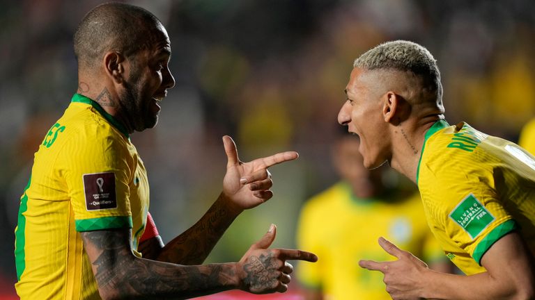 Richarlison celebrates with team-mate Dani Alves after scoring Brazil's fourth goal against Bolivia 