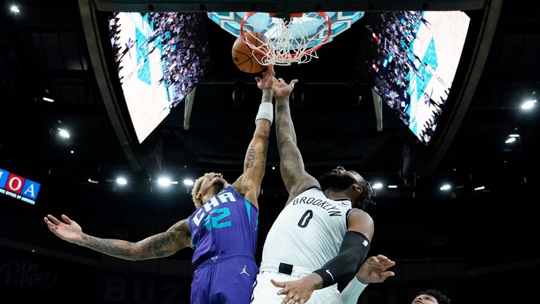 Brooklyn Nets center Andre Drummond scores between Charlotte Hornets guard Kelly Oubre Jr., left, and forward Miles Bridges