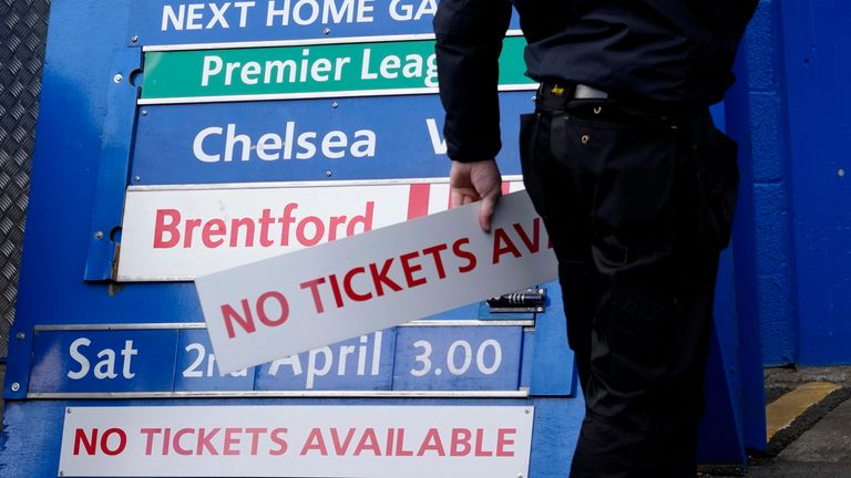 Ein Mitglied des Bodenpersonals passt eine Spieltafel vor dem bevorstehenden Premier-League-Spiel zwischen Chelsea und Newcastle an der Stamford Bridge (AP) an.