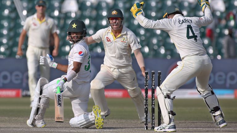 Pakistan&#39;s Hasan Ali, second left, looks back to wickets while Australian players celebrate after his dismissal on the fifth day of the third test match between Pakistan and Australia at the Gaddafi Stadium in Lahore, Pakistan, Friday, March 25, 2022.