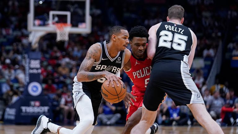 San Antonio Spurs center Jakob Poeltl (25) sets a pick against New Orleans Pelicans forward Herbert Jones (5) as Spurs guard Dejounte Murray drives to the basket in the first half of an NBA basketball game in New Orleans, Saturday, March 26, 2022. (AP Photo/Gerald Herbert)