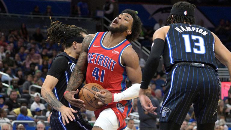 Detroit Pistons forward Saddiq Bey is fouled by Orlando Magic guard Cole Anthony while driving to the basket as Magic guard R.J. Hampton watches