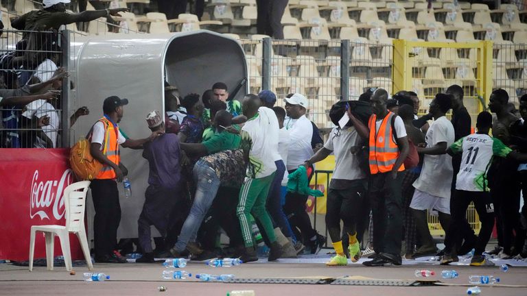 Ghana's football players run off the pitch after it was invaded at the end of the 2022 Qatar World Cup qualifying playoff second leg at Moshood Abiola Stadium, in Abuja, Nigeria