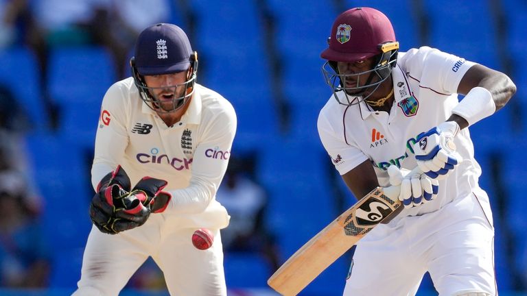West Indies&#39; Jason Holder plays a shot watched by England&#39;s keeper Ben Foakes during day five of their first cricket Test match at the Sir Vivian Richards Cricket Ground in North Sound, Antigua and Barbuda, Saturday, March 12, 2022. (AP Photo/Ricardo Mazalan)