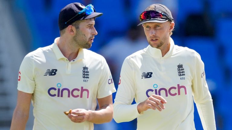 England's captain Joe Root, right, talks to bowler Mark Wood during day two of their first cricket Test match against West Indies at the Sir Vivian Richards Cricket Ground in North Sound, Antigua and Barbuda, Tuesday, March 8, 2022. (AP Photo/Ricardo Mazalan)