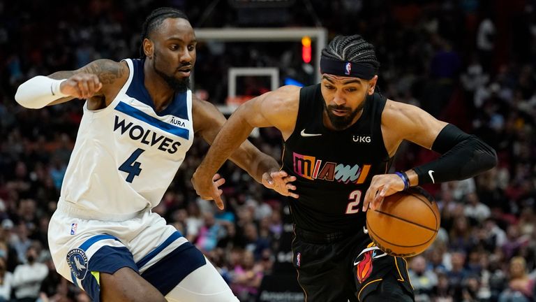 Miami Heat guard Gabe Vincent dribbles the ball as Minnesota Timberwolves guard Jaylen Nowell defends during the second half of an NBA basketball game.