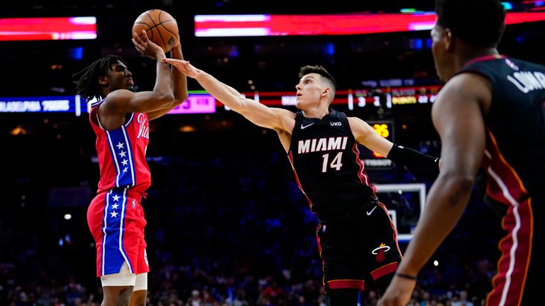 Tyrese Maxey (left) of the Philadelphia 76ers hits Tyler Herro of the Miami Heat (center) during the second half of an NBA basketball game on Monday, March 21, 2022, in Philadelphia. 