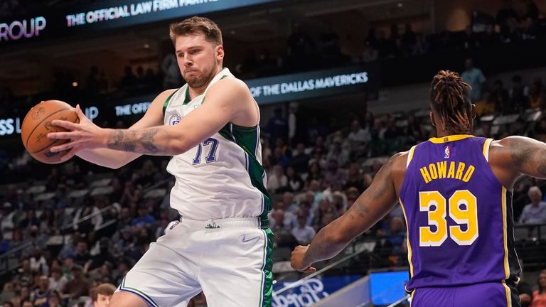 Dallas Mavericks guard Luka Doncic grabs a rebound in front of Los Angeles Lakers center Dwight Howard during the first quarter of an NBA basketball game in Dallas, Tuesday, March 29, 2022.