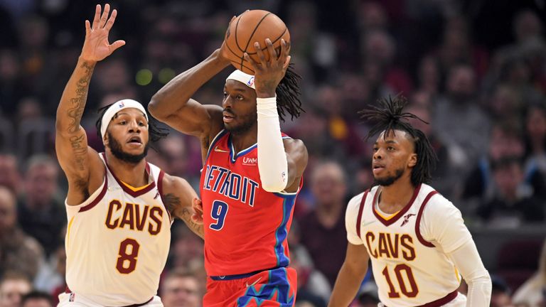 Detroit Pistons forward Jerami Grant looks to pass the ball as Cleveland Cavaliers&#39; Lamar Stevens and Darius Garland defend during the first half of an NBA basketball game Saturday, March 19, 2022, in Cleveland. 