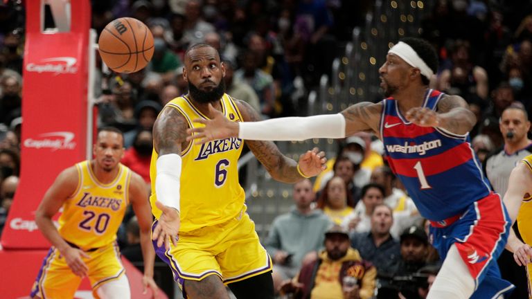 Los Angeles Lakers&#39; LeBron James and Washington Wizards&#39; Kentavious Caldwell-Pope reach for the ball during the second half of an NBA basketball game, Saturday, March 19, 2022, in Washington.