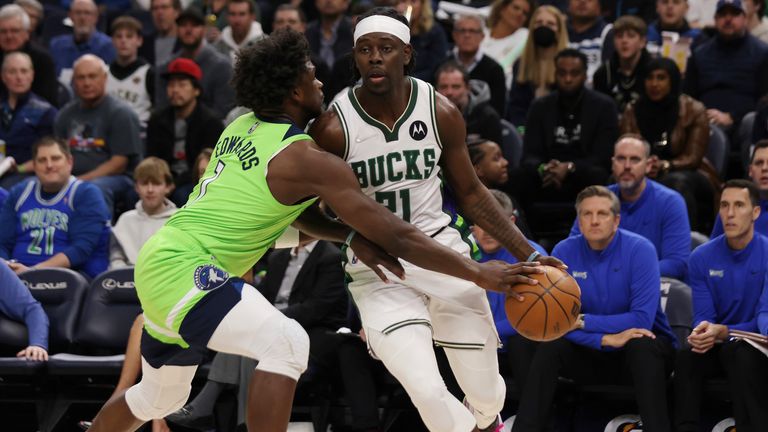 Minnesota Timberwolves forward Anthony Edwards tries to knock the ball away from Milwaukee Bucks guard Jrue Holiday during the first half of an NBA basketball game Saturday, March 19, 2022, in Minneapolis.