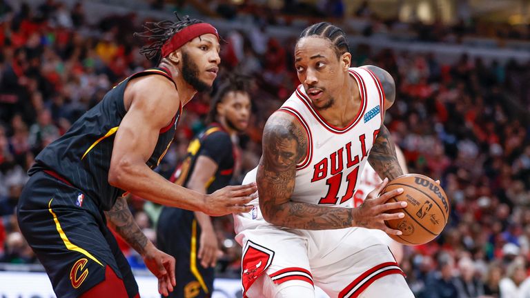 Chicago Bulls forward DeMar DeRozan, right, looks to shoot against Cleveland Cavaliers forward Lamar Stevens, left, during the second half of an NBA basketball game, Saturday, March 12, 2022, in Chicago. (AP Photo/Kamil Krzaczynski)