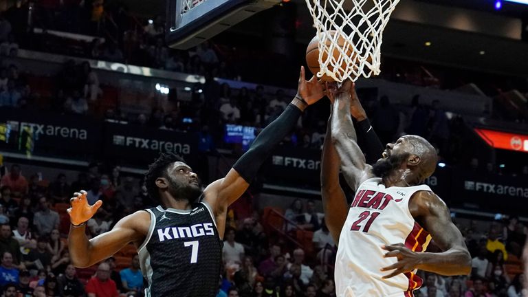 Miami Heat center Dewayne Dedmon (21) attempts to block a shot to the basket by Sacramento Kings forward Chimezie Metu (7) during the first half of an NBA basketball game, Monday, March 28, 2022, in Miami.