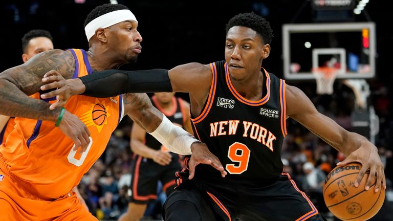 New York Knicks guard RJ Barrett (9) spins on Phoenix Suns forward Torrey Craig (0) during the first half of an NBA basketball game, Friday, March 4, 2022, in Phoenix. 