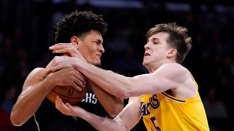 Dallas Mavericks guard Josh Green, left, and Los Angeles Lakers guard Austin Reaves grapple for the ball during the first half of an NBA basketball game