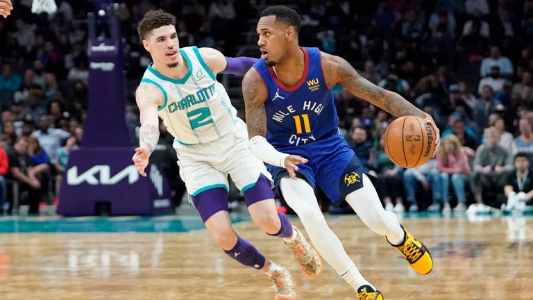 Denver Nuggets guard Monte Morris (11) dribbles around Charlotte Hornets guard LaMelo Ball (2) during the second half of an NBA basketball game on Monday, March 28, 2022, in Charlotte, N.C.