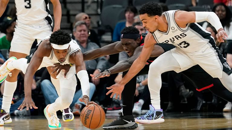 San Antonio Spurs guard Josh Richardson, left, and guard Tre Jones, right, and Toronto Raptors forward Pascal Siakam, center, chase the ball during the second half of an NBA basketball game Wednesday, March 9, 2022, in San Antonio.