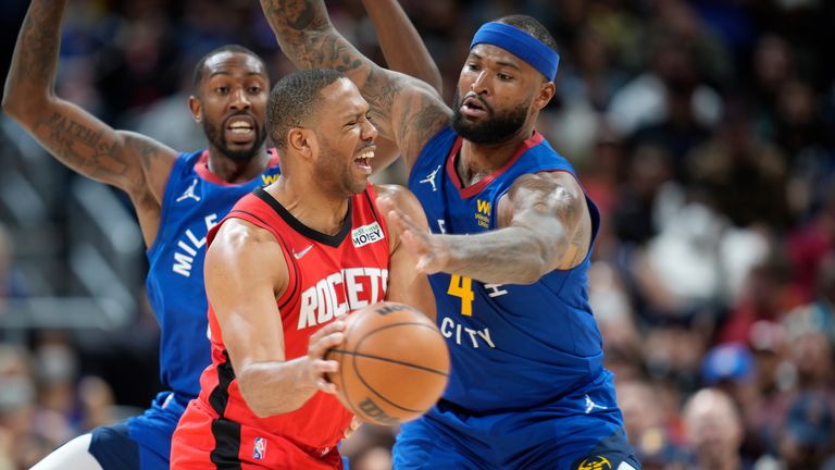 Houston Rockets guard Eric Gordon, center, passes the ball under pressure from Denver Nuggets guard Davon Reed, left, and center DeMarcus Cousins in the second half of an NBA basketball game Friday, March 4, 2022, in Denver. The Nuggets won 116-101.