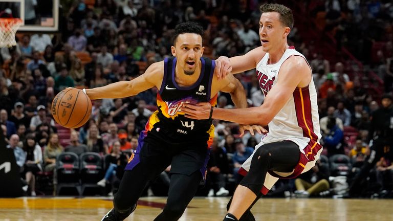 Miami Heat guard Duncan Robinson (55) defends Phoenix Suns guard Landry Shamet (14) during the first half of an NBA basketball game, Wednesday, March 9, 2022, in Miami.