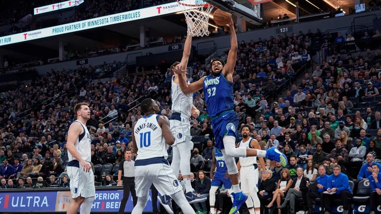 Minnesota Timberwolves center Karl-Anthony Towns (32) goes up for a dunk as Dallas Mavericks forward Maxi Kleber defends and forward Dorian Finney-Smith (10) watches during the first half of an NBA basketball game Friday, March 25, 2022, in Minneapolis. (AP Photo/Craig Lassig)


