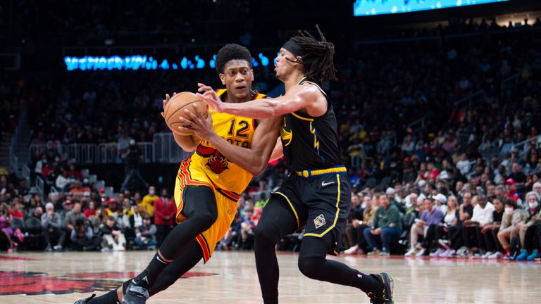 Atlanta Hawks forward De&#39;Andre Hunter (12) drives to the basket past Golden State Warriors guard Damion Lee (1) during the first half of an NBA basketball game Friday, March 25, 2022, in Atlanta. (AP Photo/Hakim Wright Sr.)


