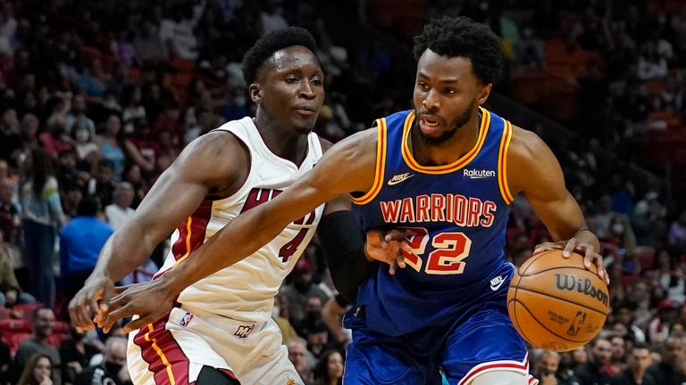 Golden State Warriors forward Andrew Wiggins (22) dribbles the ball around Miami Heat guard Victor Oladipo (4) during the first half of an NBA basketball game, Wednesday, March 23, 2022, in Miami.