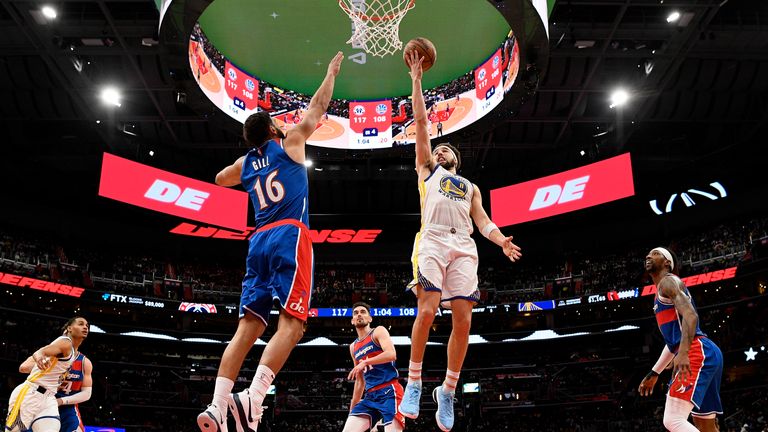 Golden State Warriors guard Klay Thompson (11) goes to the basket against Washington Wizards forward Anthony Gill (16), guard Tomas Satoransky (31) and guard Kentavious Caldwell-Pope, right, during the second half of an NBA basketball game, Sunday, March 27, 2022, in Washington.