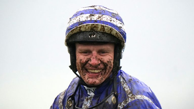 A mud-soaked Paul Townend smiles after Energumene's victory in the Champion Chase