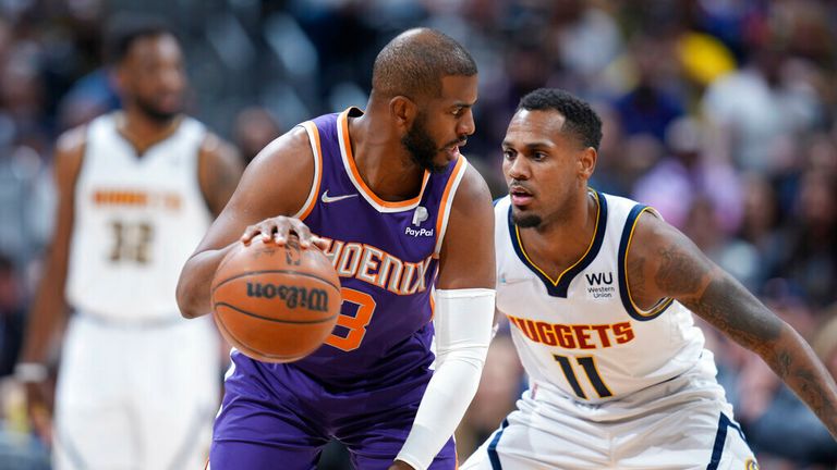 Phoenix Suns guard Chris Paul, left, is defended by Denver Nuggets guard Monte Morris during the first half of an NBA basketball game Thursday, March 24, 2022, in Denver. (AP Photo/David Zalubowski)