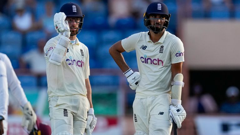 England's Saqib Mahmood, right, and teammate Jack Leach wait for the play to resume during their partnership on day one of their third Test cricket match against West Indies at the National Cricket Stadium in St. George, Grenada, Thursday, March 24, 2022. (AP Photo/Ricardo Mazalan)