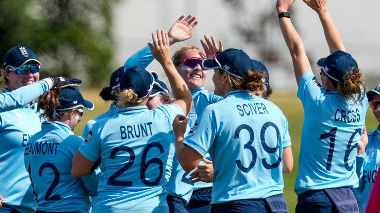 Sophie Ecclestone is congratulated by her England team-mates after taking a wicket vs India