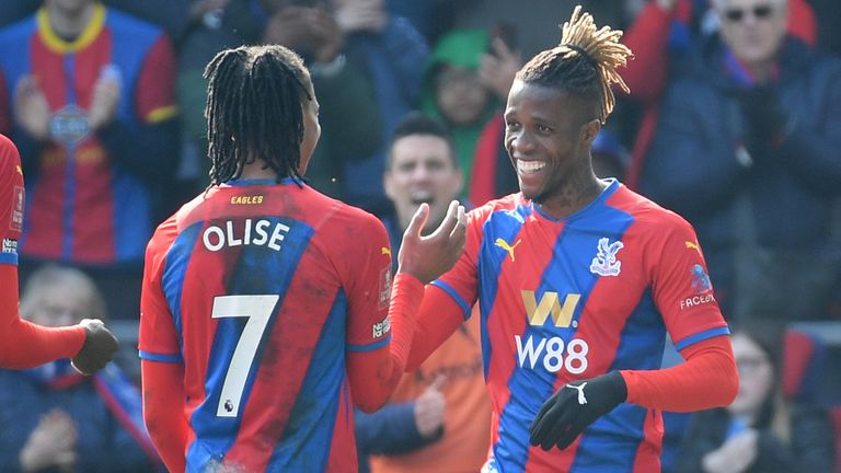 Wilfried Zaha celebrates with team-mates after scoring their side's third goal